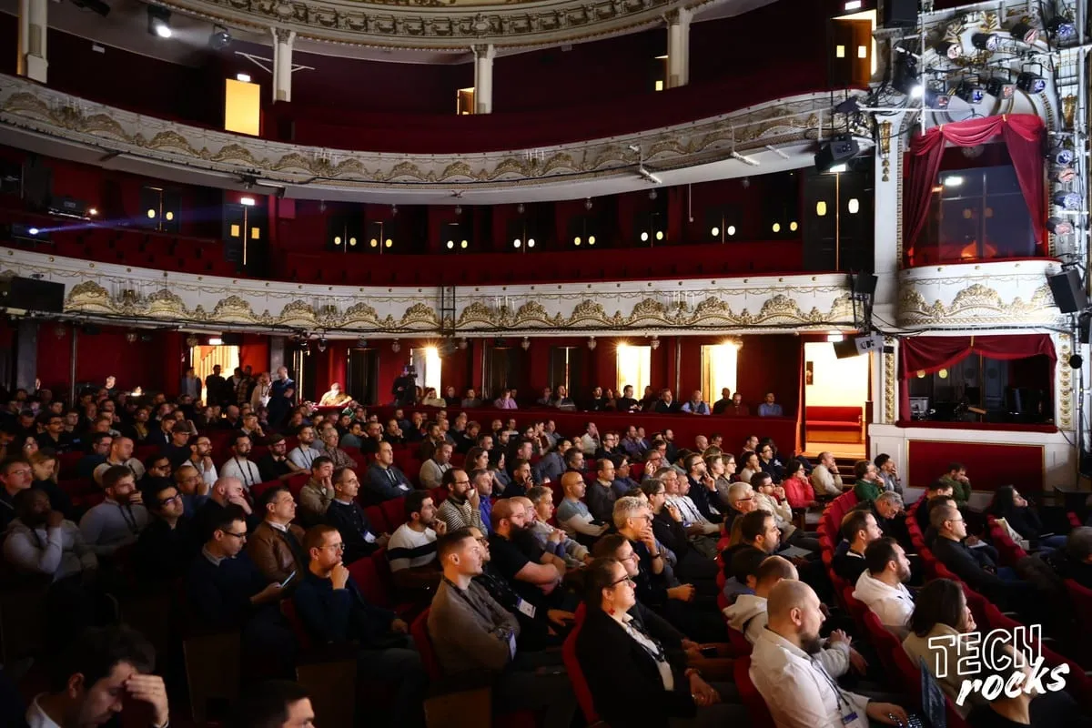 Une salle de théâtre comble pendant le Tech.Rocks Summit : le parterre et les balcons remplis de participant·es