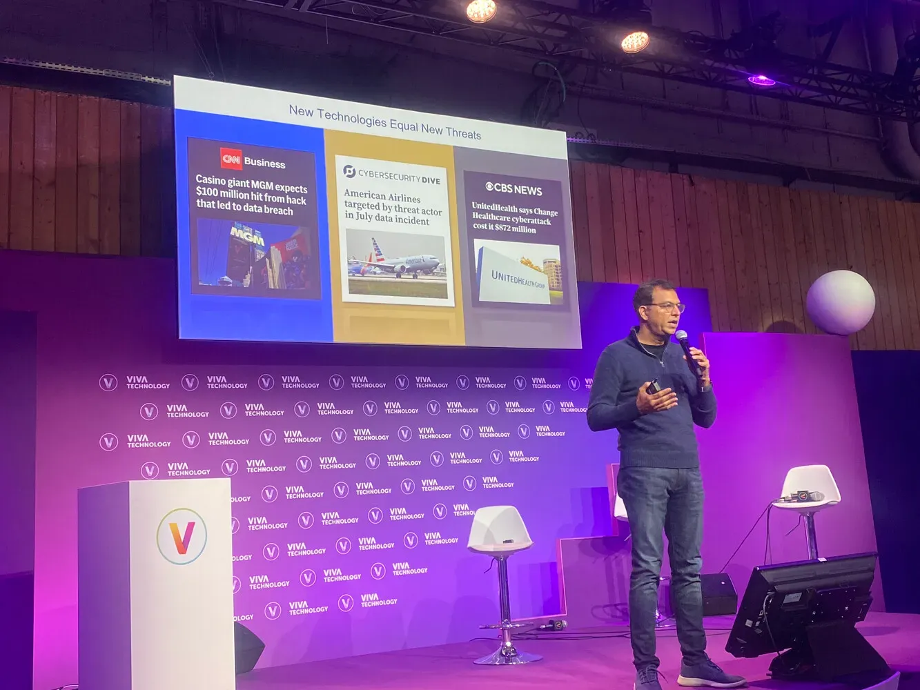 VivaTech 2024, Exec Arena : un intervenant au micro devant l’écran « New Technologies Equal New Threats », qui montre des titres de presse sur des cyberattaques