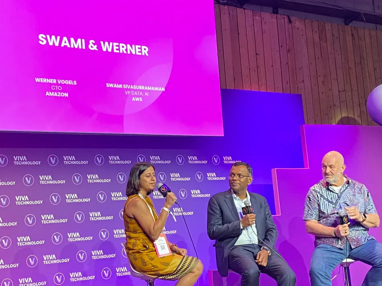 VivaTech 2024, Exec Arena : une modératrice et deux intervenants assis sous l’écran « Swami & Werner » (Werner Vogels, CTO d’Amazon, et Swami Sivasubramanian, VP Data & AI d’AWS)